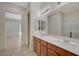 Bright bathroom with double sinks, large mirrors, and tile flooring at 370 Mano Destra Ln, Henderson, NV 89011