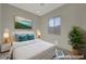 Staged bedroom with a bed, artwork, and a plant, creating an inviting and comfortable atmosphere at 370 Mano Destra Ln, Henderson, NV 89011
