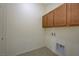 An organized laundry room features tile floors, overhead cabinets, and utility connections for efficient home maintenance at 370 Mano Destra Ln, Henderson, NV 89011