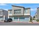 Modern two-story home featuring gray stucco, a balcony, and light blue garage doors against a blue sky at 4932 Chidlaw Ave # 2, Las Vegas, NV 89115