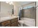 Bright bathroom featuring a shower over tub, a single sink vanity with wood cabinets and a neutral color palette at 5450 Barnwood Ct, Pahrump, NV 89061