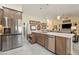 Kitchen showcasing stainless steel appliances, wood cabinets, and an island with sink and pullout drawer at 5450 Barnwood Ct, Pahrump, NV 89061