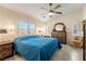 Bright main bedroom with large windows, wooden dresser and blue bedding at 5450 Barnwood Ct, Pahrump, NV 89061