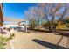 Spacious backyard with covered patio, gravel, mature trees and barbecue area at 5552 Singing Hills Dr, Las Vegas, NV 89130