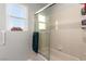 Clean bathroom featuring a shower, bath tub combo, window and decorative wall hangings at 5552 Singing Hills Dr, Las Vegas, NV 89130