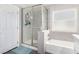 Bathroom with a glass-enclosed shower, bathtub, and a frosted window allowing natural light at 5552 Singing Hills Dr, Las Vegas, NV 89130