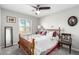 Well-lit bedroom with a full-sized bed, ceiling fan, and large window overlooking the backyard at 5552 Singing Hills Dr, Las Vegas, NV 89130