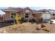 Attractive single-story home showcasing a desert-style yard, tile roof, and a two-car garage at 5552 Singing Hills Dr, Las Vegas, NV 89130
