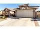 Close-up of the home showing a two-car garage, gated entrance, and desert landscaping at 5552 Singing Hills Dr, Las Vegas, NV 89130