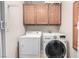 Laundry room featuring a white washer and dryer set with built-in storage cabinets for organization at 5552 Singing Hills Dr, Las Vegas, NV 89130