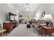 Spacious living room with a ceiling fan, vaulted ceilings, large windows, and neutral decor at 5552 Singing Hills Dr, Las Vegas, NV 89130