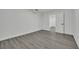 Finished basement with gray wood-look flooring, white walls, and an open doorway at 7060 S Valley View Blvd, Las Vegas, NV 89118