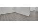 Finished basement with gray wood-look flooring, white walls, and a doorway at 7060 S Valley View Blvd, Las Vegas, NV 89118