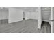Finished basement with gray wood-look flooring leading to stairs and an open doorway at 7060 S Valley View Blvd, Las Vegas, NV 89118