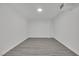 Finished basement with gray wood-look flooring, white walls, and recessed lights at 7060 S Valley View Blvd, Las Vegas, NV 89118
