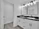 Well-lit bathroom with dual sinks, marble countertop, updated fixtures, and a door to the toilet at 7060 S Valley View Blvd, Las Vegas, NV 89118