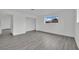 Bedroom featuring gray wood-look floors, bright natural light and hallway access at 7060 S Valley View Blvd, Las Vegas, NV 89118