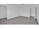 Bedroom featuring gray wood-look floors, white walls, and ample closet space at 7060 S Valley View Blvd, Las Vegas, NV 89118