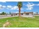 White single-story home with a gray garage, palm trees, and grass lawn at 7060 S Valley View Blvd, Las Vegas, NV 89118