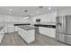Modern kitchen with marble countertops, stainless steel appliances, a center island, and a washer/dryer at 7060 S Valley View Blvd, Las Vegas, NV 89118