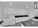 This bright, all-white kitchen has a laundry nook and sleek, modern counters with a striking black marble design at 7060 S Valley View Blvd, Las Vegas, NV 89118