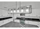 Bright kitchen with an island, stainless appliances, white cabinetry and modern lighting, exuding style and functionality at 7060 S Valley View Blvd, Las Vegas, NV 89118