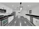 A spacious kitchen showcasing a central island, modern appliances, white cabinetry, and sleek black marble countertops at 7060 S Valley View Blvd, Las Vegas, NV 89118