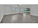 Open-plan living room with sleek flooring, neutral paint, and sliding glass doors to backyard at 7060 S Valley View Blvd, Las Vegas, NV 89118