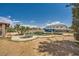 Backyard oasis showcasing a unique in-ground pool, mature palm trees, and ample space for outdoor activities at 7079 Laredo St, Las Vegas, NV 89117