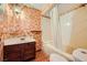 Bathroom featuring floral wallpaper, a marble sink, and a bathtub at 7079 Laredo St, Las Vegas, NV 89117