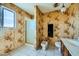 Functional bathroom with floral wallpaper, a tiled shower, toilet, and classic vanity at 7079 Laredo St, Las Vegas, NV 89117