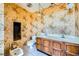 Bathroom featuring floral wallpaper, dual sinks, a toilet, and ample counter space at 7079 Laredo St, Las Vegas, NV 89117