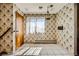 Eat-in kitchen with vintage wallpaper, wooden door, and tiled floors at 7079 Laredo St, Las Vegas, NV 89117