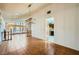 Open living room with wood floors, large windows, and an adjacent eat-in kitchen at 7079 Laredo St, Las Vegas, NV 89117