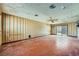 Spacious living room with outdated wallpaper, ceiling fan, and a sliding glass door at 7079 Laredo St, Las Vegas, NV 89117