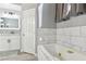 Modern bathroom with a marble tiled bathtub and a vanity with a patterned backsplash at 7621 Gosport Ave, Las Vegas, NV 89131