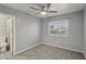 Bedroom featuring gray walls, carpet, and a window with blinds. Adjacent is an en-suite bathroom at 7621 Gosport Ave, Las Vegas, NV 89131