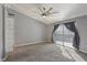 Bedroom featuring a large ceiling fan, carpet, access to an outdoor patio and a bathroom at 7621 Gosport Ave, Las Vegas, NV 89131