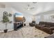 A well lit living room with recessed lighting, wood plank flooring, a sectional sofa, and a large TV at 7621 Gosport Ave, Las Vegas, NV 89131