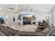 A spacious living room with recessed lighting, wood plank flooring, a sectional sofa, and a large TV at 7621 Gosport Ave, Las Vegas, NV 89131