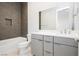 Stylish bathroom featuring gray hexagon tile, a modern vanity with a large mirror, and a soaking tub at 856 Watford Pl, Henderson, NV 89011