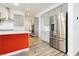 View of the kitchen, showcasing the stainless steel refrigerator and the island with a red accent at 856 Watford Pl, Henderson, NV 89011