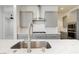 Modern kitchen with stainless steel sink, gray cabinets, white backsplash and stone countertops at 856 Watford Pl, Henderson, NV 89011