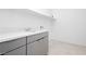 Modern laundry room with gray cabinets, white countertop, tile flooring, and a convenient storage shelf at 856 Watford Pl, Henderson, NV 89011