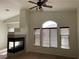Spacious living area with a decorative ceiling fan, tiled fireplace, and ample natural light at 8680 Horizon Wind Ave # 101, Las Vegas, NV 89178