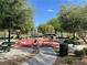 Outdoor exercise area featuring various fitness equipment, picnic tables, and manicured landscaping and walkways at 8680 Horizon Wind Ave # 101, Las Vegas, NV 89178