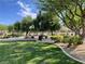 Community park featuring lush green lawns, mature shade trees, park benches, and well-maintained landscaping at 8680 Horizon Wind Ave # 101, Las Vegas, NV 89178