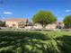 Green neighborhood common area with a mature tree and a view of townhomes with fenced yards at 8680 Horizon Wind Ave # 101, Las Vegas, NV 89178