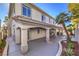 Home's rear exterior shows a covered patio with columns, adjacent to a landscaped yard with palm trees under a blue sky at 8864 La Manga Ave, Las Vegas, NV 89147