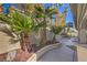 Landscaped backyard featuring palm trees, decorative rock, and concrete pathway, providing a serene outdoor space at 8864 La Manga Ave, Las Vegas, NV 89147